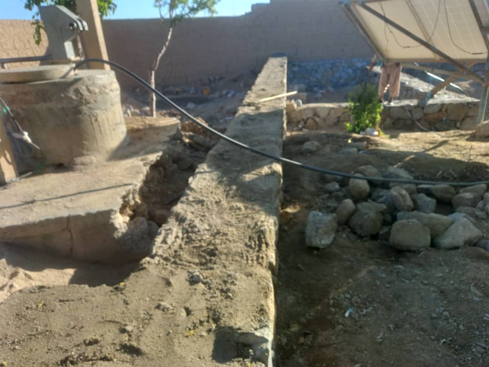 Concrete drainage channel along the boundary wall at Captain Taj Mohammad Khan Lycee, with solar panels visible