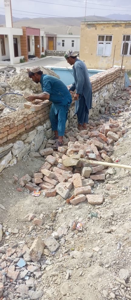 Workers building the brick and stone boundary wall